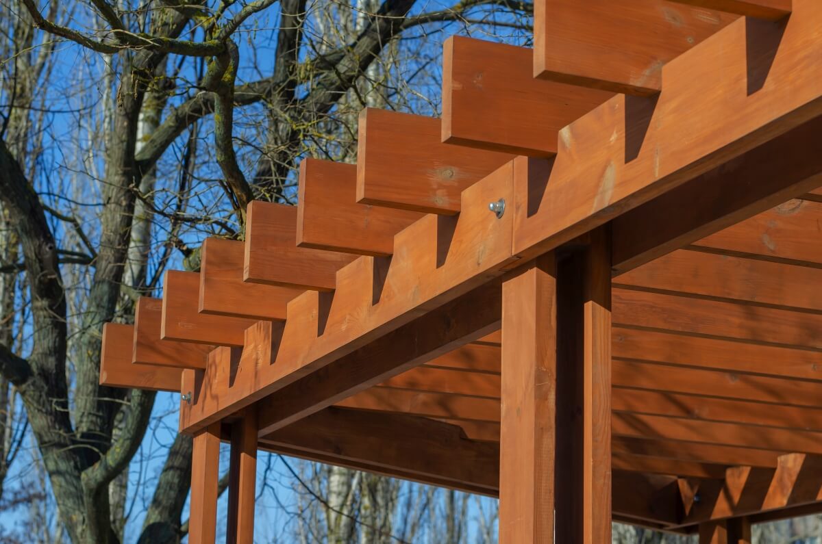 A wooden structure built from planks for gazebos among the trees.