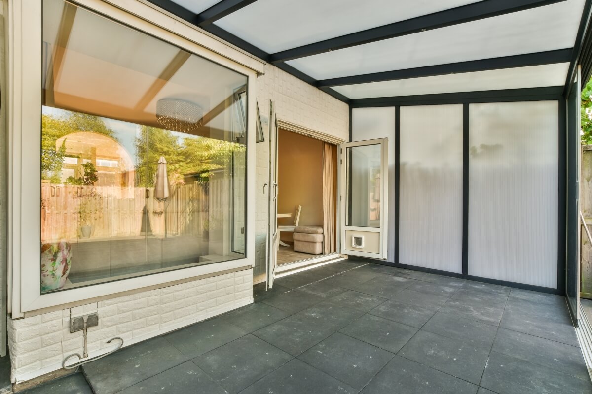 Spacious terrace with lamella roofing and glazed walls.
