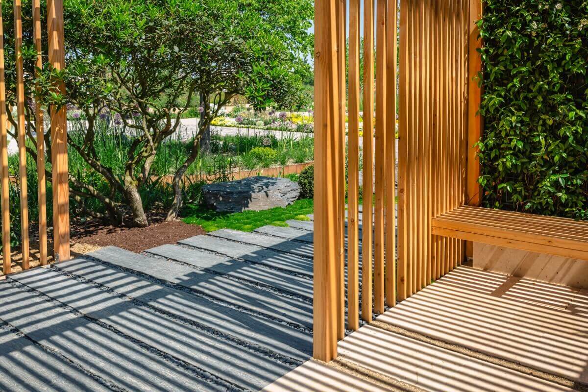 Movable pergola boards are visible in the garden, casting shadows on the floor.