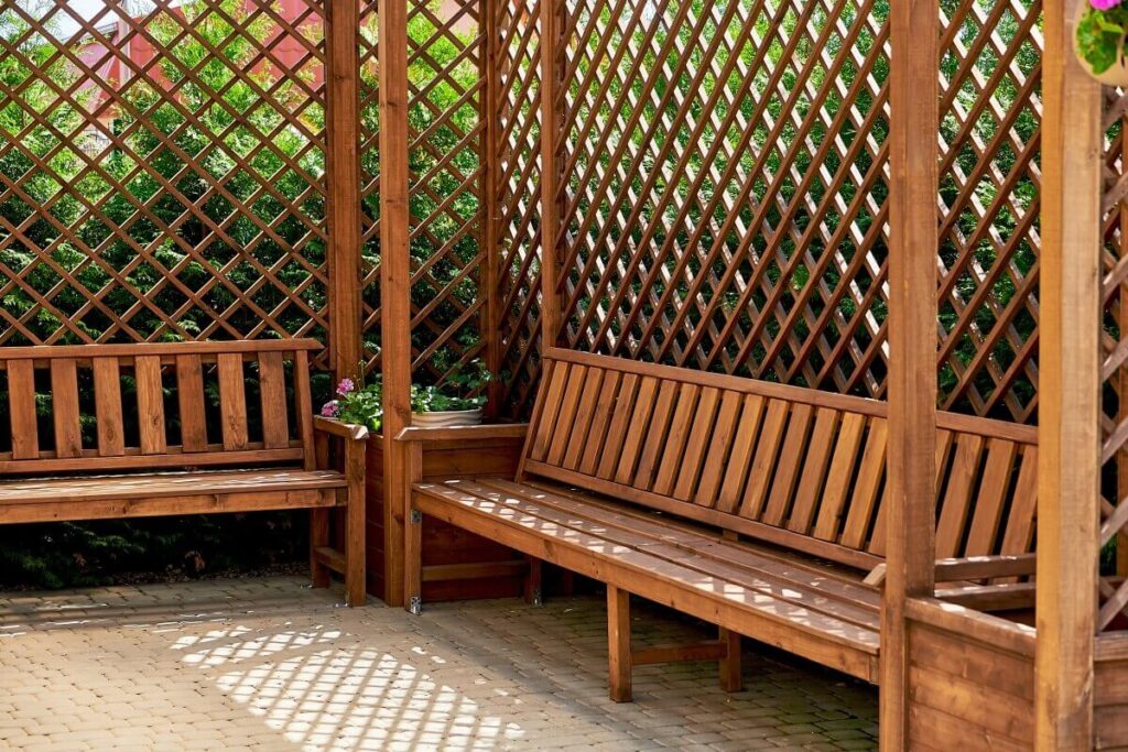 Drewniana altana z ławkami i kratkowymi ściankami do altan drewnianych.